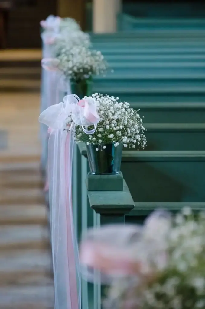 Kirchendeko zur Trauung: Blumenschmuck an der Kirchenbank